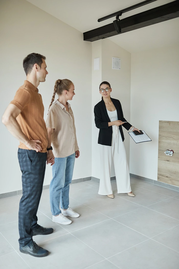 mujer enseñando piso a una pareja